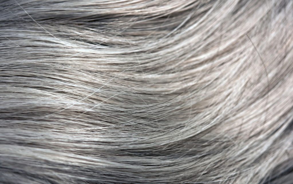 A është e dëmshme të shkulësh fijet e thinjura të flokëve?